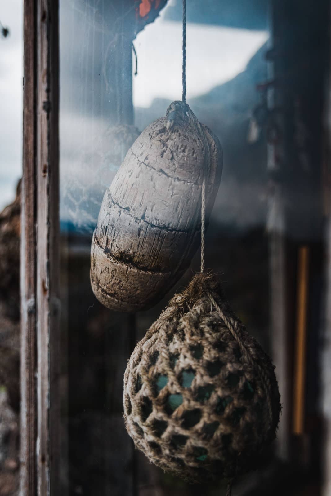 Dekoartikel hängen im Fenster einer alten Strandhütte von Hadseløya in Norwegen