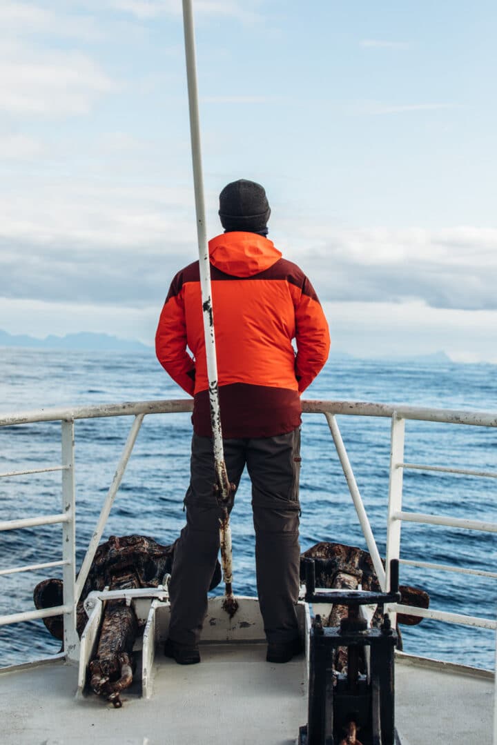 Mann steht am Bug des Walsafari Andenes Schiff - Hvalsafari AS, Norwegen