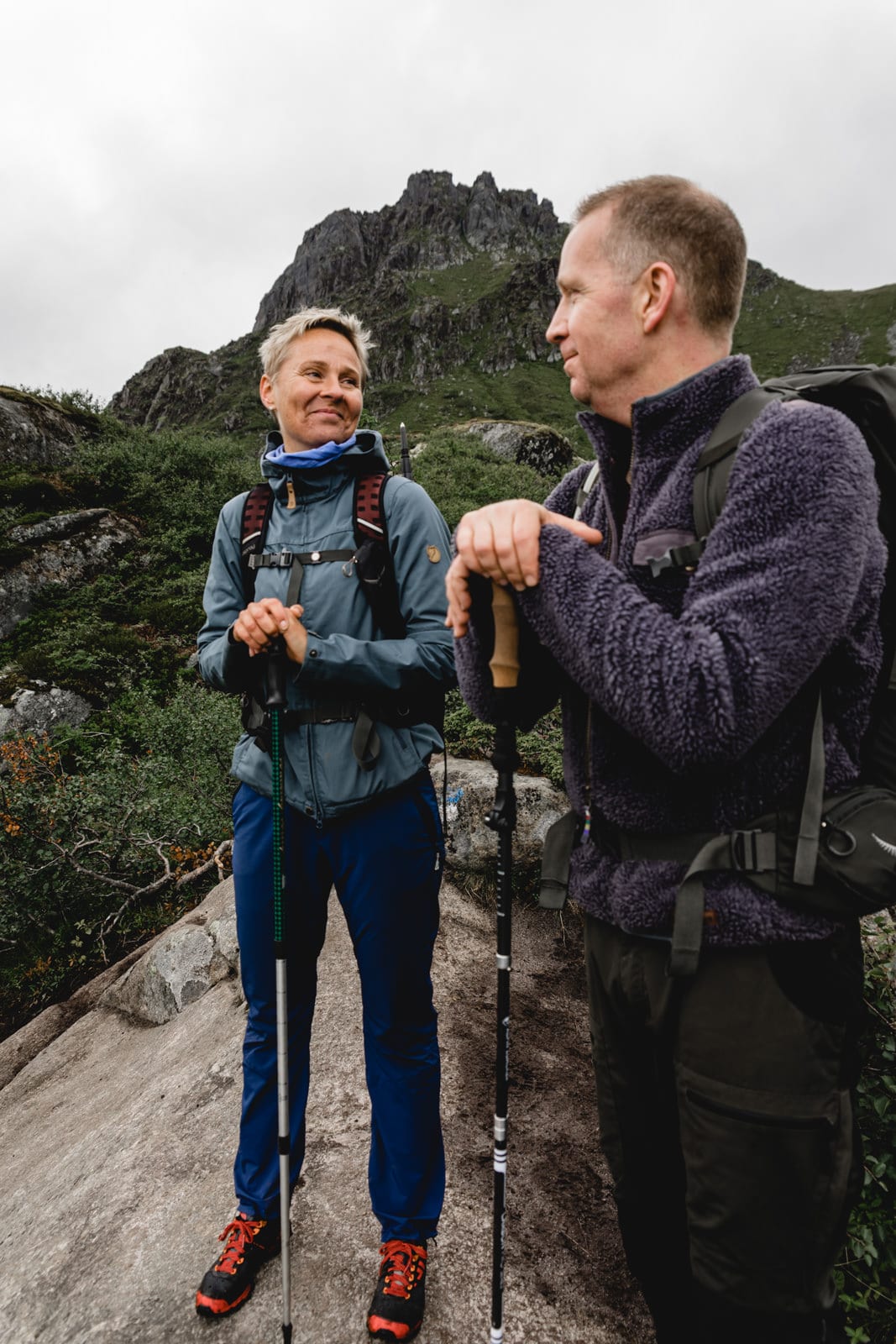 Mann und Frau lachen sich auf einer Wanderung in Norwegen an. Fløya & Djevelporten, Lofoten