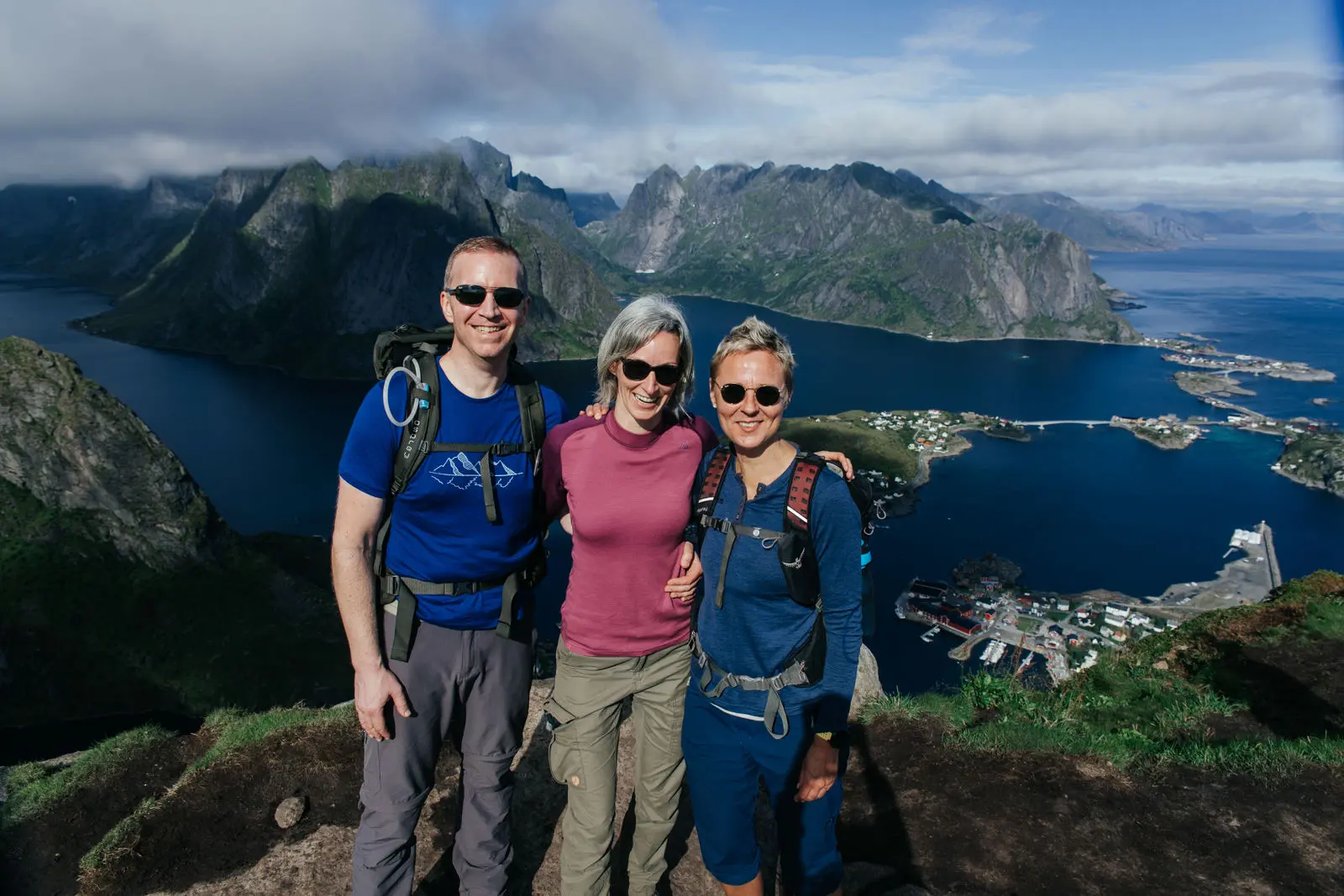 Drei Menschen stehen auf dem Berg bei Reinebringen in Norwegen und lachen in die Kamera