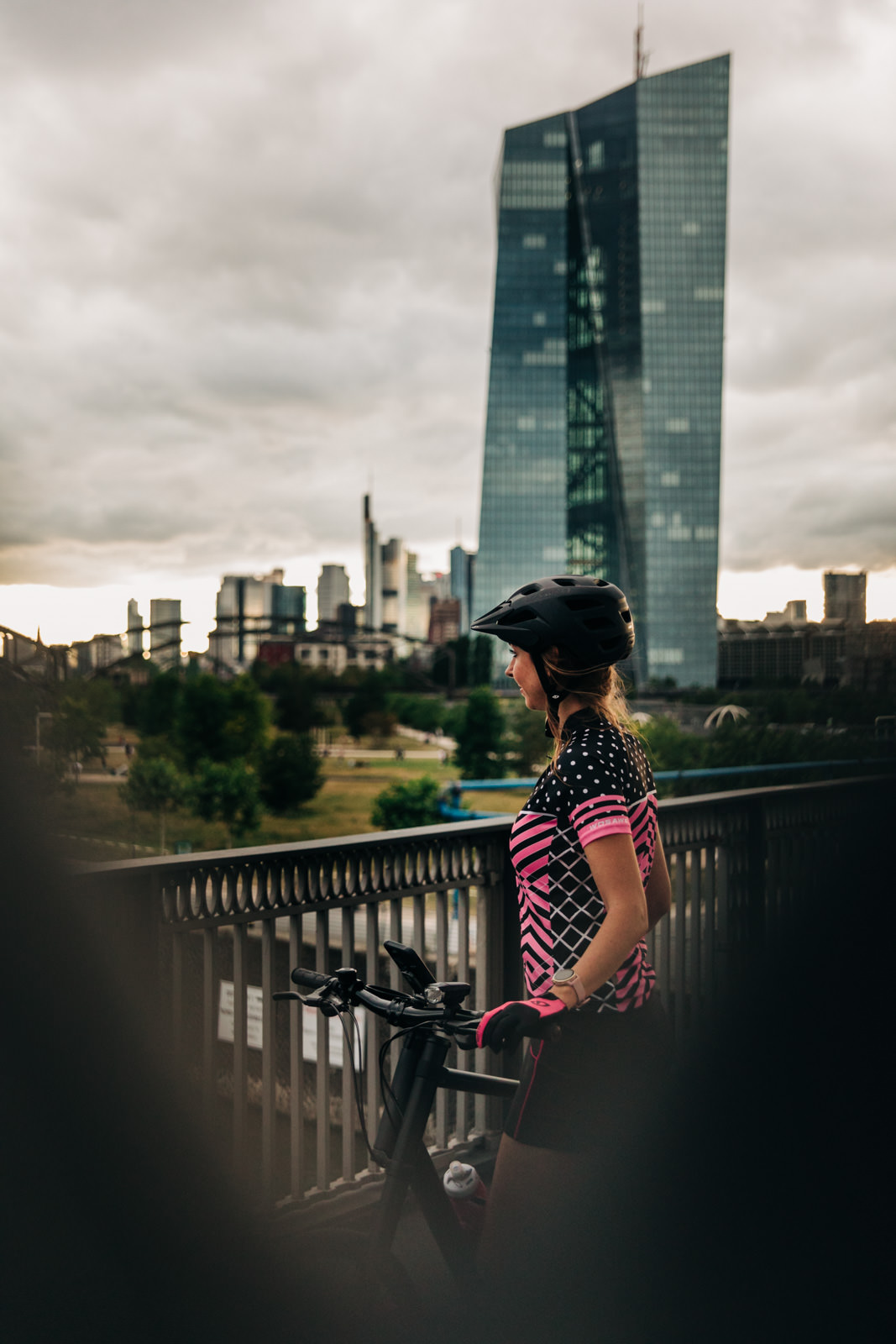 Frau mit Fahrrad vor der Skyline Frankfurt