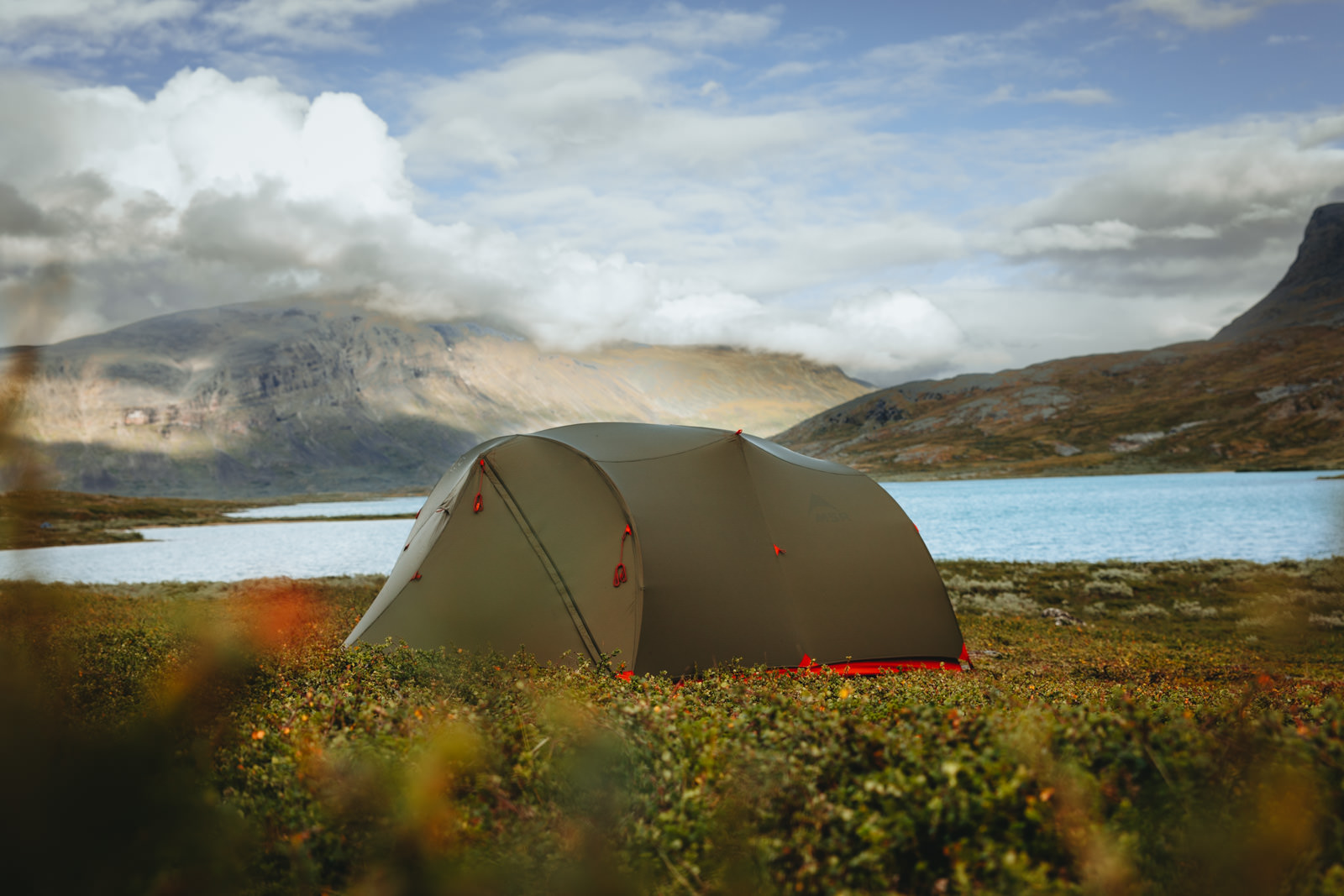 Ein Zelt der Firma MSR steht am Flussufer im schwedischen Lappland