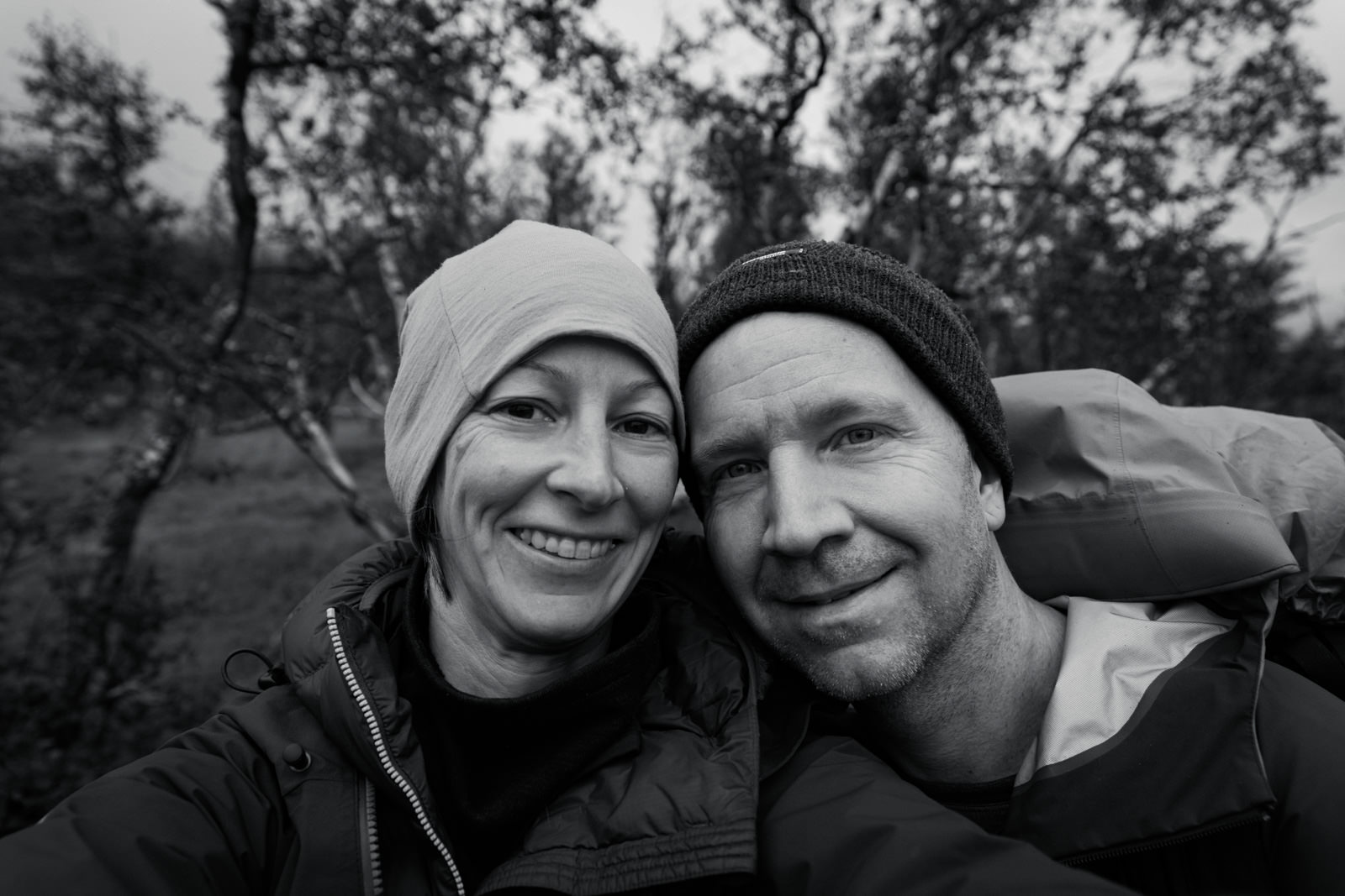 Mann und Frau lachen in die Kamera beim Trekking in Schweden